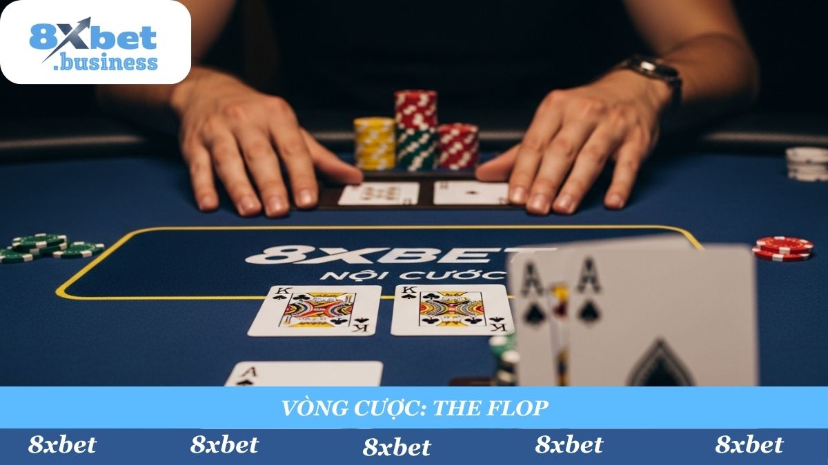 A 16:9 aspect ratio, photorealistic, point-of-view (POV) shot from a player's perspective. The player's two "hole cards" (e.g., Ace of Spades, King of Spades) are seen in the foreground. In the mid-ground, the "Flop" (three community cards) has just been dealt face-up on the 8xbet-branded table. The "Pot" (nồi cược) of chips is visible in the center. Tense, strategic atmosphere, cinematic lighting, shallow depth of field focusing on the Flop.